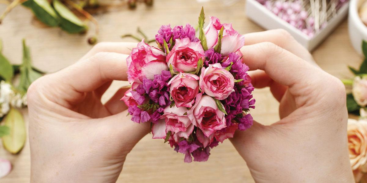 Hands preparing bouquet.